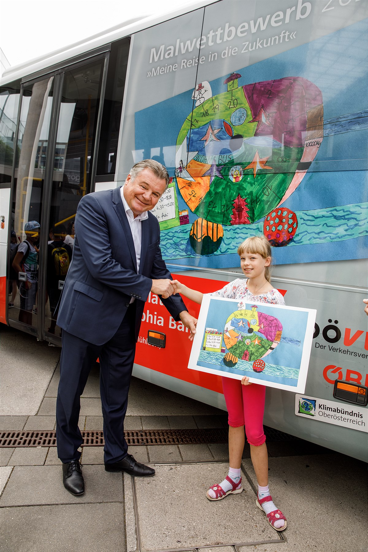 Landesrat Günther Steinkellner gratuliert der Siegerin Sophie Hammer zu Ihrer Zeichnung Wohn-Bus-Boot